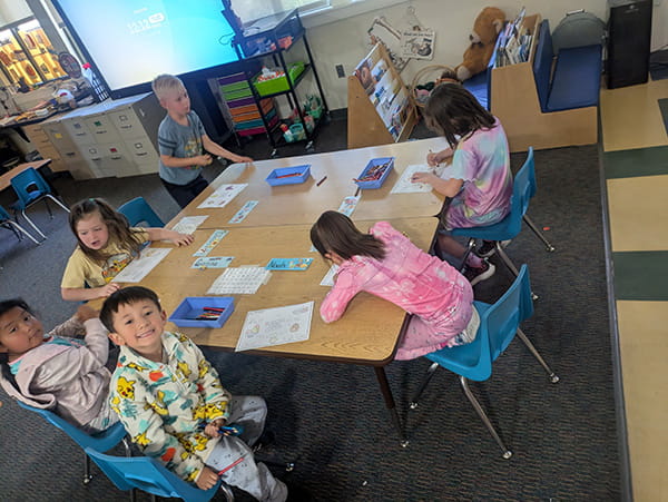 Six students at tables coloring