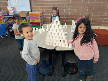 Kindergarten students showing off their stacked cup tower