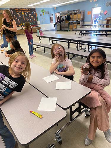 three students eating donuts