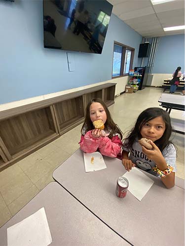 two students eating donuts