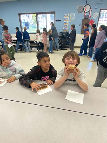 two students eating donuts