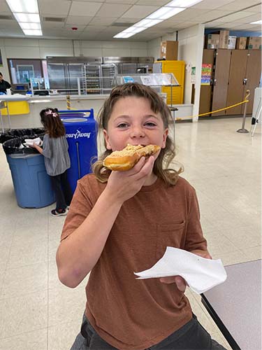 male student eating a donut