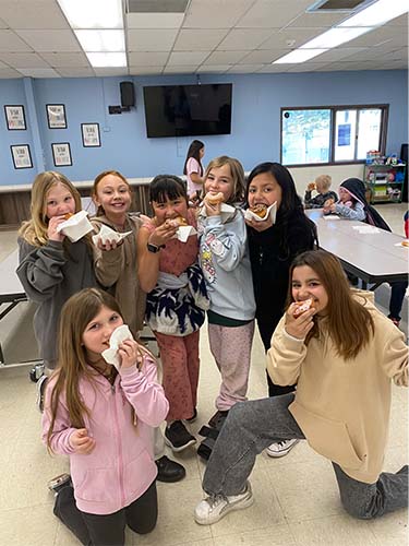 group of students eating donuts