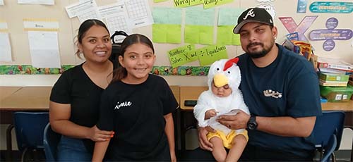 Baby in chicken costume with family
