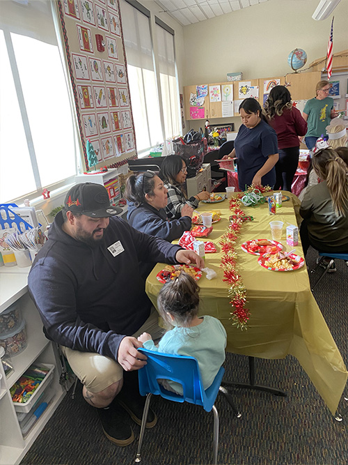 Parents eating at a decorated table with students