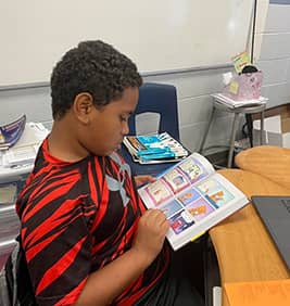 Boy reading book at his desk