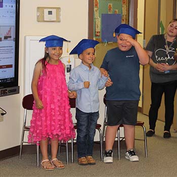 Three students with graduation caps on