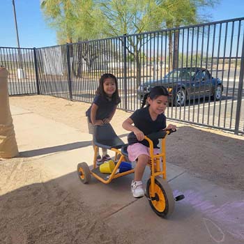 Two preschoolers riding a bike