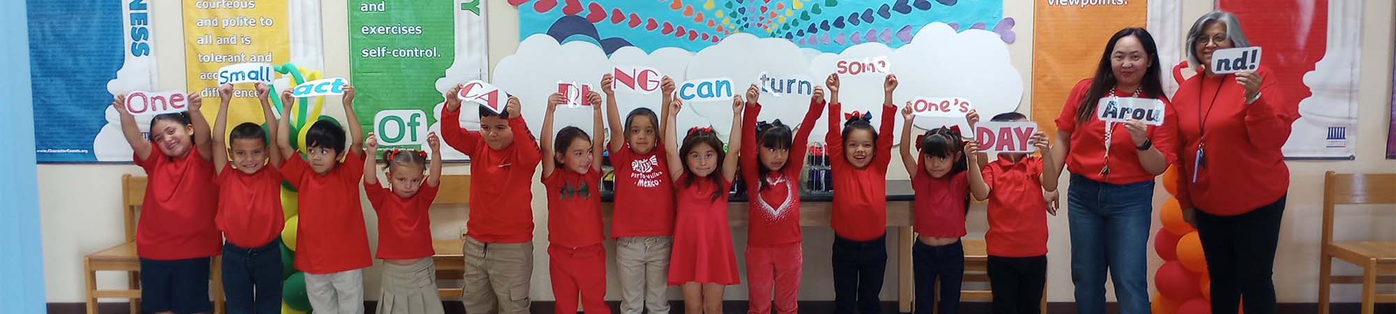 Students in red shirts holding signs