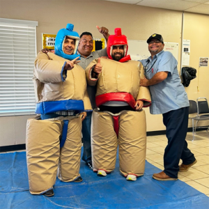 Two staff members in sumo wrestling suits