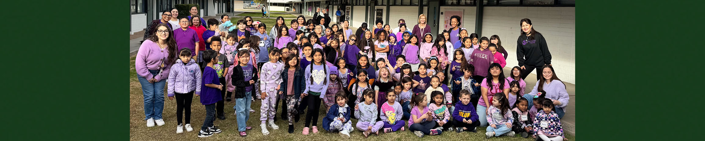 Group photo of students and adults outside campus