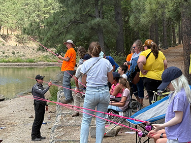Students fishing along a river bank
