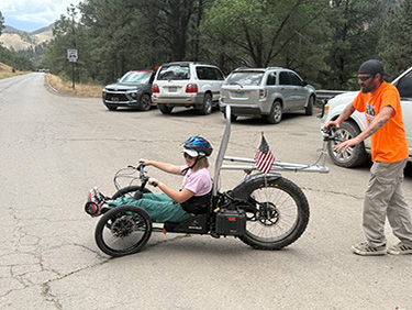 Student riding an adaptive bicycle
