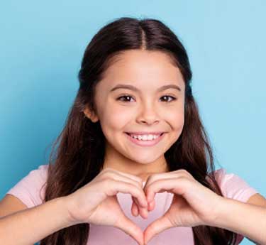 girls making the shape of a heart with her hands