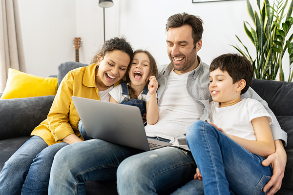 Family looking at laptop and laughing