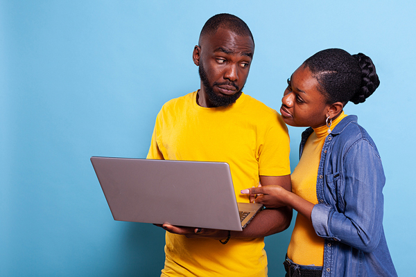 confused couple viewing a laptop